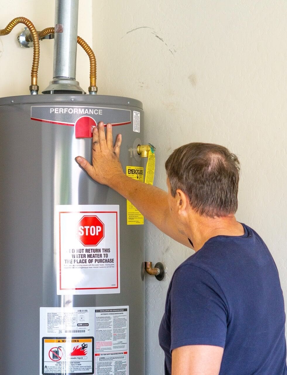 Adult male with hand on newly installed hot water system