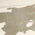 Water-stained concrete floor indicating potential slab leak in residential property.